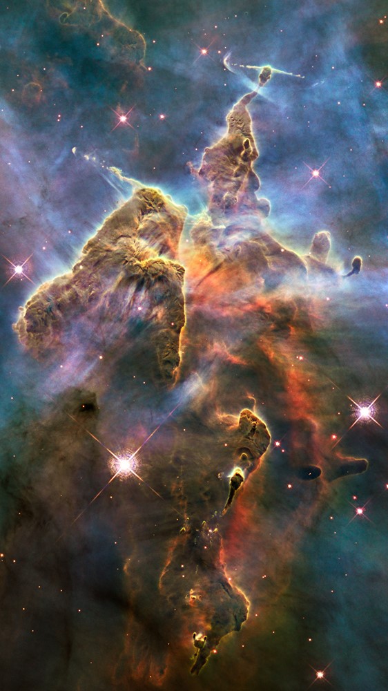 a billowing cloud of cold interstellar gas and dust rising from a tempestuous stellar nursery located in the Carina Nebula, 7500 light-years away in the southern constellation of Carina