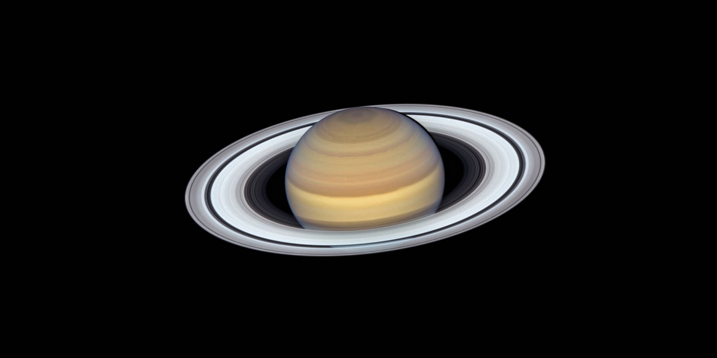 color image of the planet it Saturn with it's rings glowing brightly